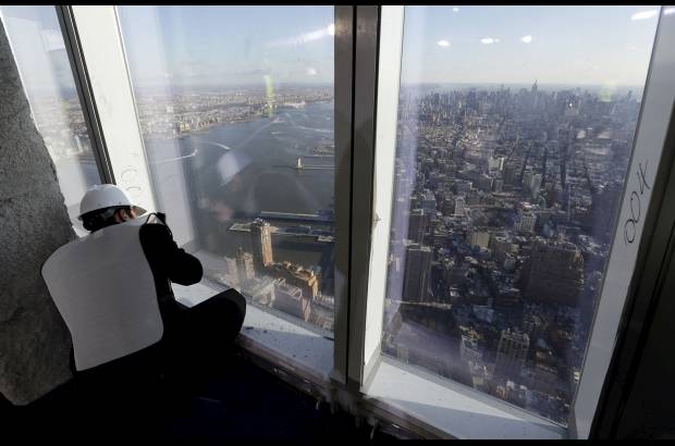 AP - Un miembro de la prensa toma una fotografía del horizonte de Manhattan desde el mirador, sin terminar, en el piso 100 del edificio One World Trade Center.