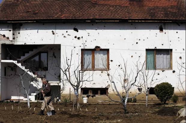 Reuters - Qemail Ismaili trabaja en frente de su casa en el pueblo de Slupcane en Macedonia. Los agujeros de bala en las paredes son un recordatorio de lo cerca que estuvo de entrar a la guerra civil en 2001, finalmente desisti&#243; por la promesa de mayores derechos y representaci&#243;n. Sin embargo, una d&#233;cada m&#225;s tarde, Ismaili est&#225; desempleado.