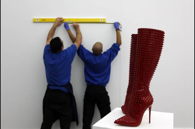 RE - Empleados de Sotheby&#39;s trabajan en la que ser&#225; la subasta llamada Rojo. Las botas Christian Louboutin hacen parte de la exhibici&#243;n.
