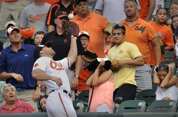 AP - El beisbolista Chris Davis, de los Orioles de Baltimore, llega hasta el p&#250;blico para atrapar una bola en el primer inning de un partido de b&#233;isbol contra los Astros de Houston.