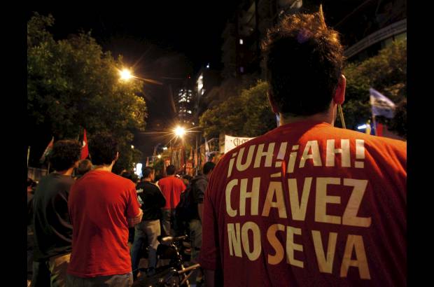 Reuters - Un partidario del presidente de Venezuela, Hugo Ch&#225;vez lleva una camiseta que dice &quot;Ch&#225;vez no se va&quot;, cante el anuncio de su muerte frente a la embajada de Venezuela en Buenos Aires.