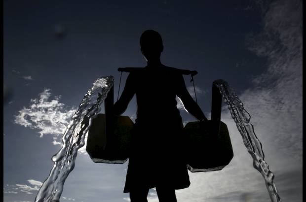 Reuters - Un granjero vierte agua que se obtiene de un pozo en Taguig City, Manila, Filipinas.