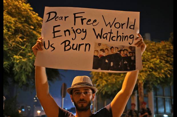 AP - Un hombre sirio que vive en Beirut, sostiene un cartel durante una vigilia por el supuesto ataque de armas qu&#237;micas en los suburbios de Damasco. El hombre est&#225; al frente a la sede de Naciones Unidas en Beirut, L&#237;bano.