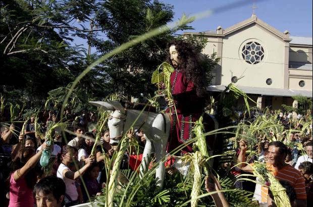 Reuters - Cat&#243;licos rodean una estatua de Cristo al participar en una procesi&#243;n durante la celebraci&#243;n de Domingo de Ramos frente a la Catedral Metropolitana de Asunci&#243;n en Paraguay.
