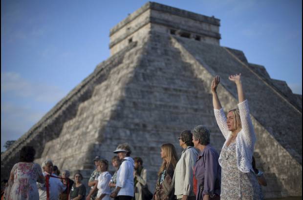 REUTERS - Decenas de grupos, la mayor&#237;a de sus integrantes vestidos de blanco, con los brazos en alto, los dedos en posici&#243;n de meditar, realizaron oraciones conjuntas de cara a la pir&#225;mide principal de Kulkulk&#225;n.