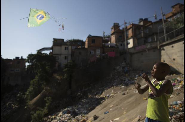 AP - En las laderas del barrio de Mangueira, un niño vuela una cometa.