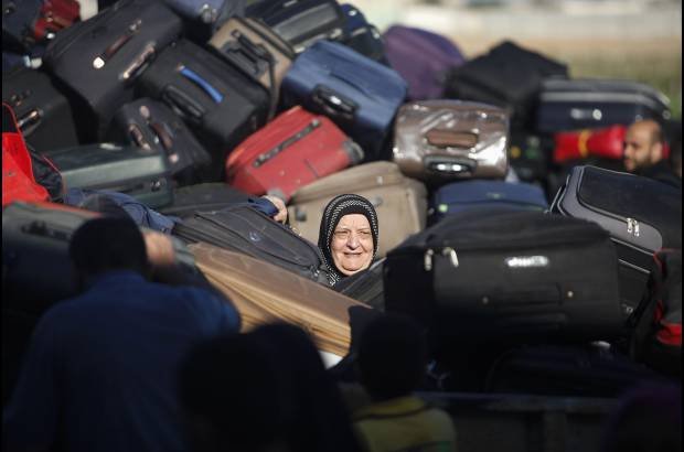 Reuters - Una pasajera palestina, busca su maleta, con la esperanza de cruzar a Egipto.