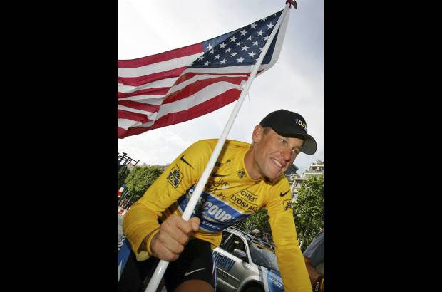 Foto AP - Lance Armstrong por la bandera de Estados Unidos como campe&#243;n del Tour con el Discovery.