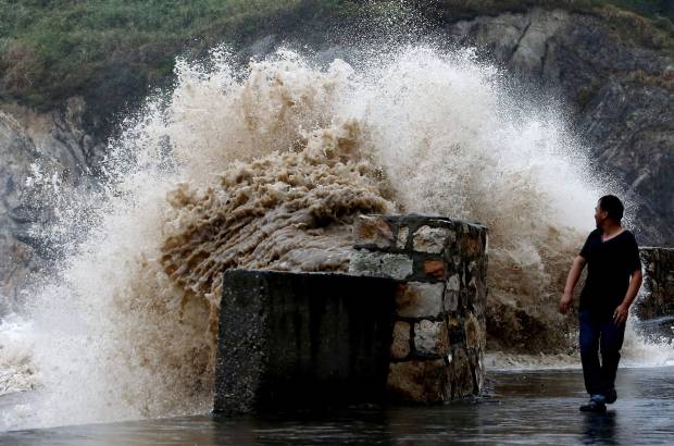 Reuters - Un hombre mira a una creciente ola en Wenling, provincia de Zhejiang. Trami, es el tif&#243;n n&#250;mero 12 que afecta a China este a&#241;o y sacudi&#243; la provincia de Fujian, este del pa&#237;s.