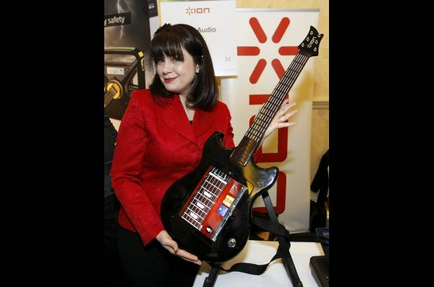Reuters - 1. La gerente de productos de Ion, Wendy Mittelstadt, muestra este control para la tableta iPad, de Apple, en forma de guitarra, que promete convertirlo en un mago del instrumento.