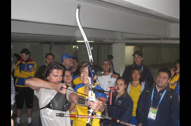 Colprensa - Juanes recibe instrucciones de la arquera Paola Alejandra Ram&#237;rez durante su visita a la Villa Panamericana.