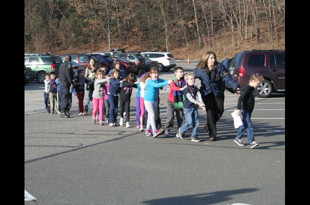 Foto Reuters - Algunos adultos escoltaron a los ni&#241;os hacia el estacionamiento, formados en fila.