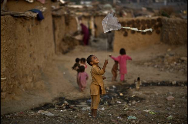 AP - Un ni&#241;o refugiado afgano juega con una cometa en un barrio pobre en las afueras de Islamabad, Pakist&#225;n.