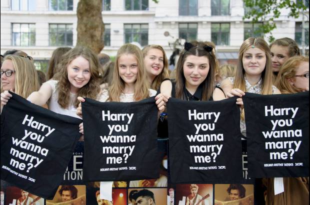 AP - Los fans del grupo One direction muestran mensajes de amor a Harry Styles en el estreno de la cinta This is us en Londres.