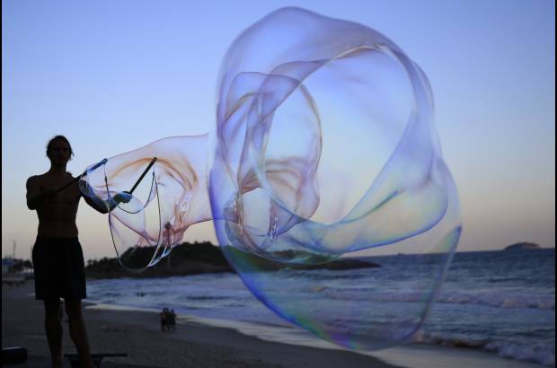 AP - Florian Timm, artista callejero alemán, de 27 años, crea burbujas gigantes de jabón en la playa de Ipanema en Río de Janeiro, Brasil.