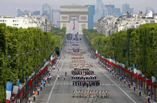REUTERS - Millares de personas presenciaron este lunes en los Campos Elíseos de París el desfile militar con el que Francia celebró su fiesta nacional