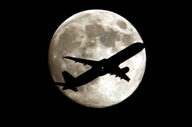 AP - Un jet se acerca al Aeropuerto Internacional de Los Angeles mostrando un bello contraste con la luna llena de esta semana.