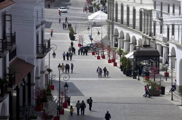 AP - Los residentes son personas adineradas que disfrutan de capuccinos y lattes al amparo de sombrillas rojas, en c&#243;modas sillas plateadas de caf&#233;s a lo largo de una calle de adoquines.