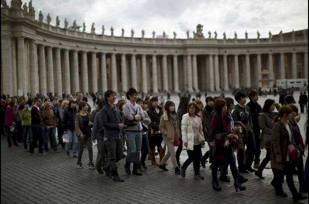AP - Los visitantes esperan su turno para entrar en la Bas&#237;lica de San Pedro en el Vaticano.