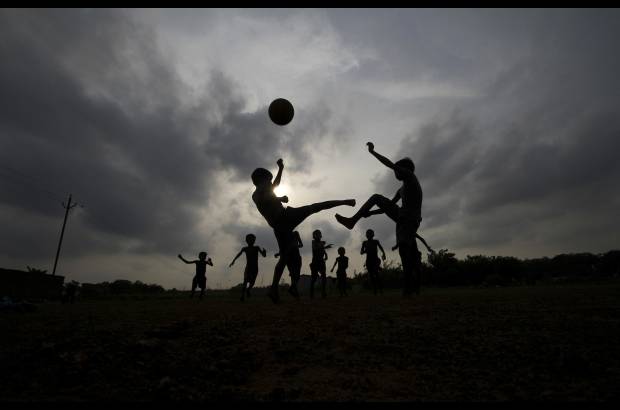 AP - Mientras los aficionados al fútbol de todo el mundo se están preparando para ver la Copa Mundial de fútbol, que se inaugura el 12 de junio, niños indios juegan al fútbol en un parque en Bhubaneswar, India.