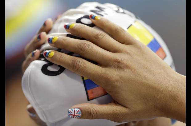 AP - La nadadora colombiana, Carolina Colorado, incluyó entre su pinta las uñas. Otro modo de vivir los Juegos.