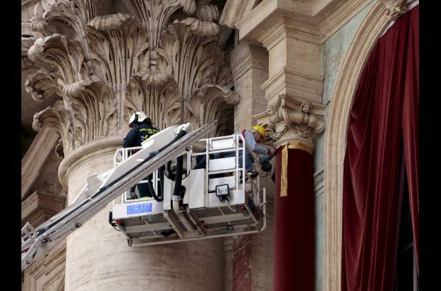 Reuters - Trabajadores pusieron una cortina roja en el balc&#243;n central, llamado la Logia de las Bendiciones de la Bas&#237;lica de San Pedro.