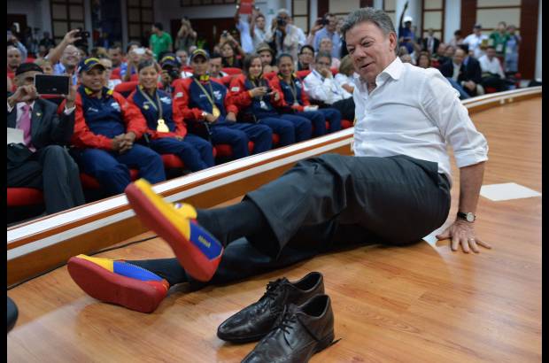 Reuters - El presidente colombiano Juan Manuel Santos se cambia los zapatos por un par que llevan los colores de la bandera de Colombia, esto en su visita a los Juegos Mundiales 2013 en Cali.