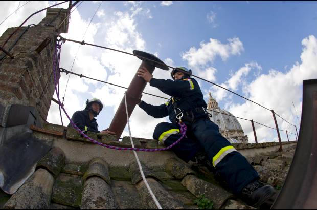 AP - Los bomberos instalan la parte superior de la chimenea de la Capilla Sixtina que se&#241;alar&#225; al mundo que un nuevo papa ha sido elegido.