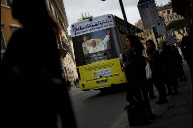 AP - Una imagen del Papa Benedicto XVI se ve en un autob&#250;s tur&#237;stico en Roma, horas antes del comienzo de la elecci&#243;n del nuevo papa.