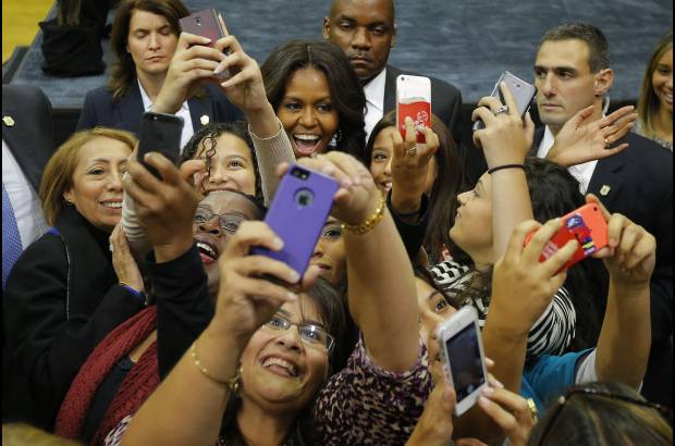 Reuters - Michelle Obama posa con el p&#250;blico que asiste a una reuni&#243;n de campa&#241;a para la candidata dem&#243;crata Gina Raimondo.