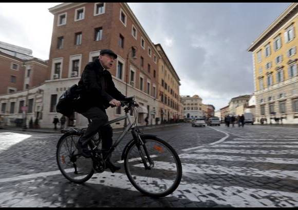 Reuters - El cardenal franc&#233;s Philippe Barbarin lleg&#243; en su bicicleta a una reuni&#243;n prec&#243;nclave en el Aula del S&#237;nodo en El Vaticano.