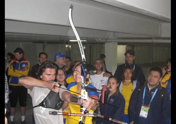 Colprensa - Juanes recibe instrucciones de la arquera Paola Alejandra Ram&#237;rez durante su visita a la Villa Panamericana.