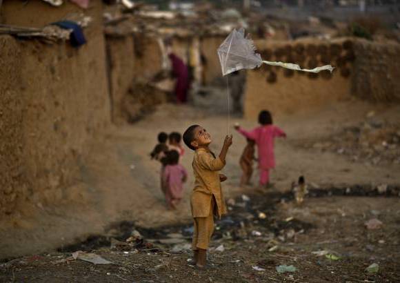 AP - Un ni&#241;o refugiado afgano juega con una cometa en un barrio pobre en las afueras de Islamabad, Pakist&#225;n.