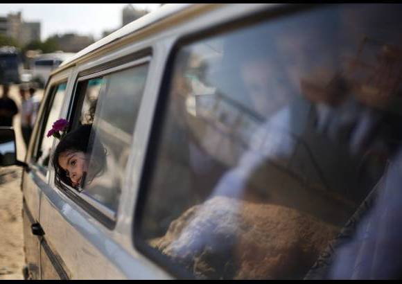 Reuters - Escolares palestinos se sientan en un autobús después de lanzar flores al puerto de la ciudad de Gaza para recordar a los inmigrantes palestinos que murieron después de que su barco se hundió mientras huía hacia Siria.