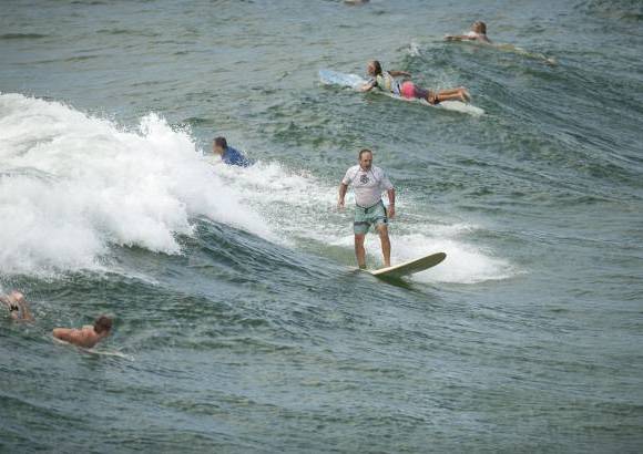 Reuters - Surfistas disfrutan de las olas en la playa Pensacola en Florida.