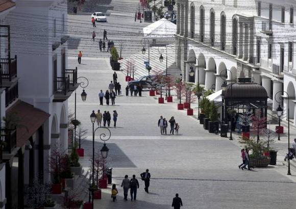 AP - Los residentes son personas adineradas que disfrutan de capuccinos y lattes al amparo de sombrillas rojas, en c&#243;modas sillas plateadas de caf&#233;s a lo largo de una calle de adoquines.