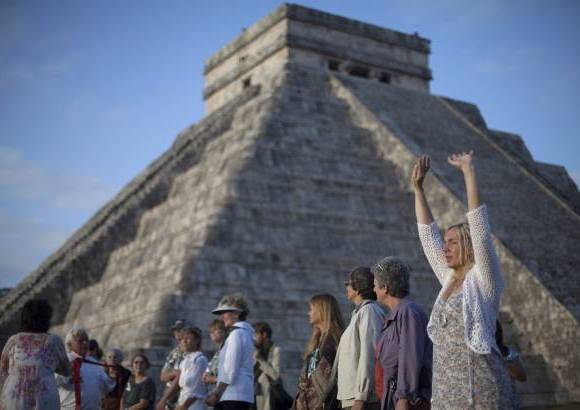 REUTERS - Decenas de grupos, la mayor&#237;a de sus integrantes vestidos de blanco, con los brazos en alto, los dedos en posici&#243;n de meditar, realizaron oraciones conjuntas de cara a la pir&#225;mide principal de Kulkulk&#225;n.