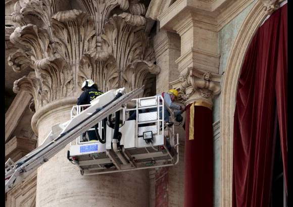 Reuters - Trabajadores pusieron una cortina roja en el balc&#243;n central, llamado la Logia de las Bendiciones de la Bas&#237;lica de San Pedro.