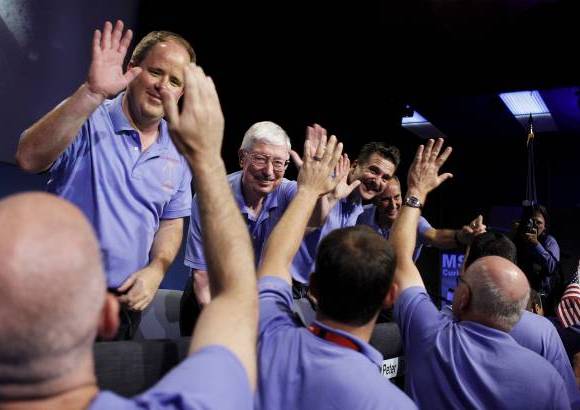Foto Reuters - El enorme paracaídas le permitieron al vehículo bajar sobre la superficie de Marte sostenido por una soga.