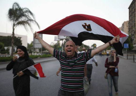 Reuters - En las calles, los opositores de Mohamed Mursi gritaron vivas para el ej&#233;rcito con la bandera nacional de Egipto, despu&#233;s de que se apostaron frente a la sede de la Guardia Republicana en El Cairo.