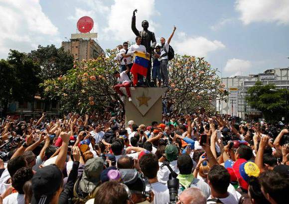 Reuters - Con la bandera de Venezuela en la mano, se trep&#243; en un monumento p&#250;blico durante la manifestaci&#243;n de sus seguidores que se oponen al gobierno de Nicol&#225;s Maduro.