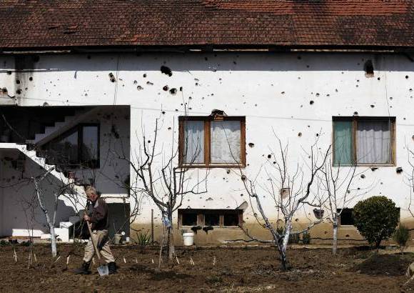 Reuters - Qemail Ismaili trabaja en frente de su casa en el pueblo de Slupcane en Macedonia. Los agujeros de bala en las paredes son un recordatorio de lo cerca que estuvo de entrar a la guerra civil en 2001, finalmente desisti&#243; por la promesa de mayores derechos y representaci&#243;n. Sin embargo, una d&#233;cada m&#225;s tarde, Ismaili est&#225; desempleado.