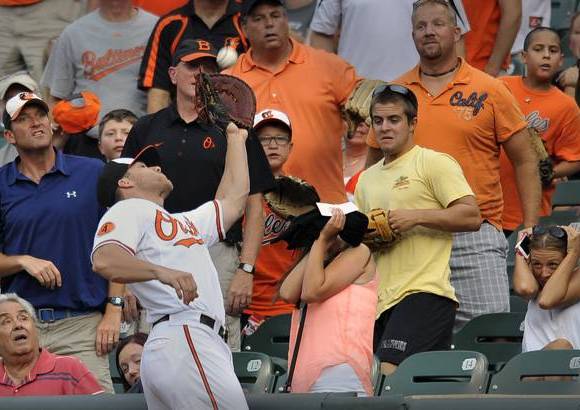AP - El beisbolista Chris Davis, de los Orioles de Baltimore, llega hasta el p&#250;blico para atrapar una bola en el primer inning de un partido de b&#233;isbol contra los Astros de Houston.