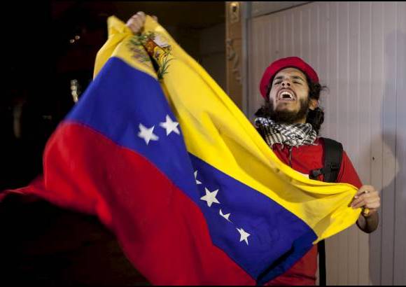 AP - Un mexicano ondea la bandera venezolana frente a la embajada de Venezuela en la Ciudad de M&#233;xico, en homenaje a Hugo Ch&#225;vez.