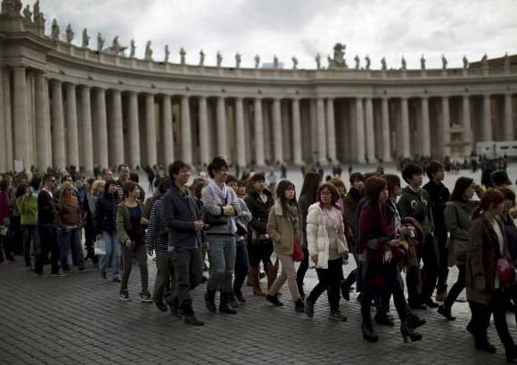 AP - Los visitantes esperan su turno para entrar en la Bas&#237;lica de San Pedro en el Vaticano.