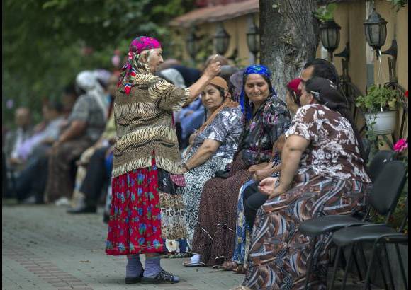AP - Una mujer gitana, que lleva un traje tradicional, habla a los dolientes del difunto rey de los roman&#237;es o gitanos, Florin Cioaba, en su casa de Sibiu, en la regi&#243;n central de Rumania, Transilvania. El rey muri&#243; a los 58 a&#241;os de un ataque al coraz&#243;n.