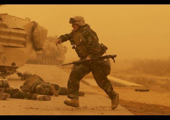 AP - Soldados de la infanter&#237;a de marina se cubren tras un ataque al sur de Bagdad el 26 de marzo de 2003.
