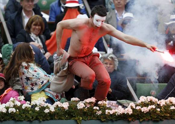 AP - Un hombre que trat&#243; de entrar en la cancha con una bengala encendida interrumpi&#243; el domingo brevemente la final del Abierto de Francia que disputaban Rafael Nadal y David Ferrer. El individuo, descamisado y con una m&#225;scara blanca, emergi&#243; de entre el p&#250;blico cercano a Nadal cuando el espa&#241;ol estaba por hacer su saque en el segundo set en ventaja de 5-1. El intruso ten&#237;a escrito en el vientre la leyenda &quot;Derechos de los ni&#241;os&quot;.