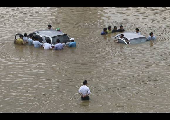 AP - Un hombre mira a otros vehículos inundados después de una lluvia torrencial que azotó la zona metropolitana de Seúl, Corea del Sur.