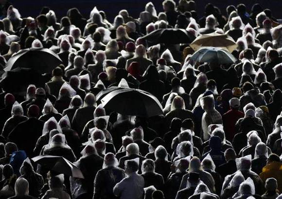 Reuters - Los fieles católicos escuchan al Papa Francisco bajo la lluvia en la playa de Copacabana en Río de Janeiro, en el cuarto día de su visita para el Día Mundial de la Juventud.